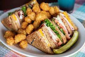 Classic club sandwich with tater tots and pickle