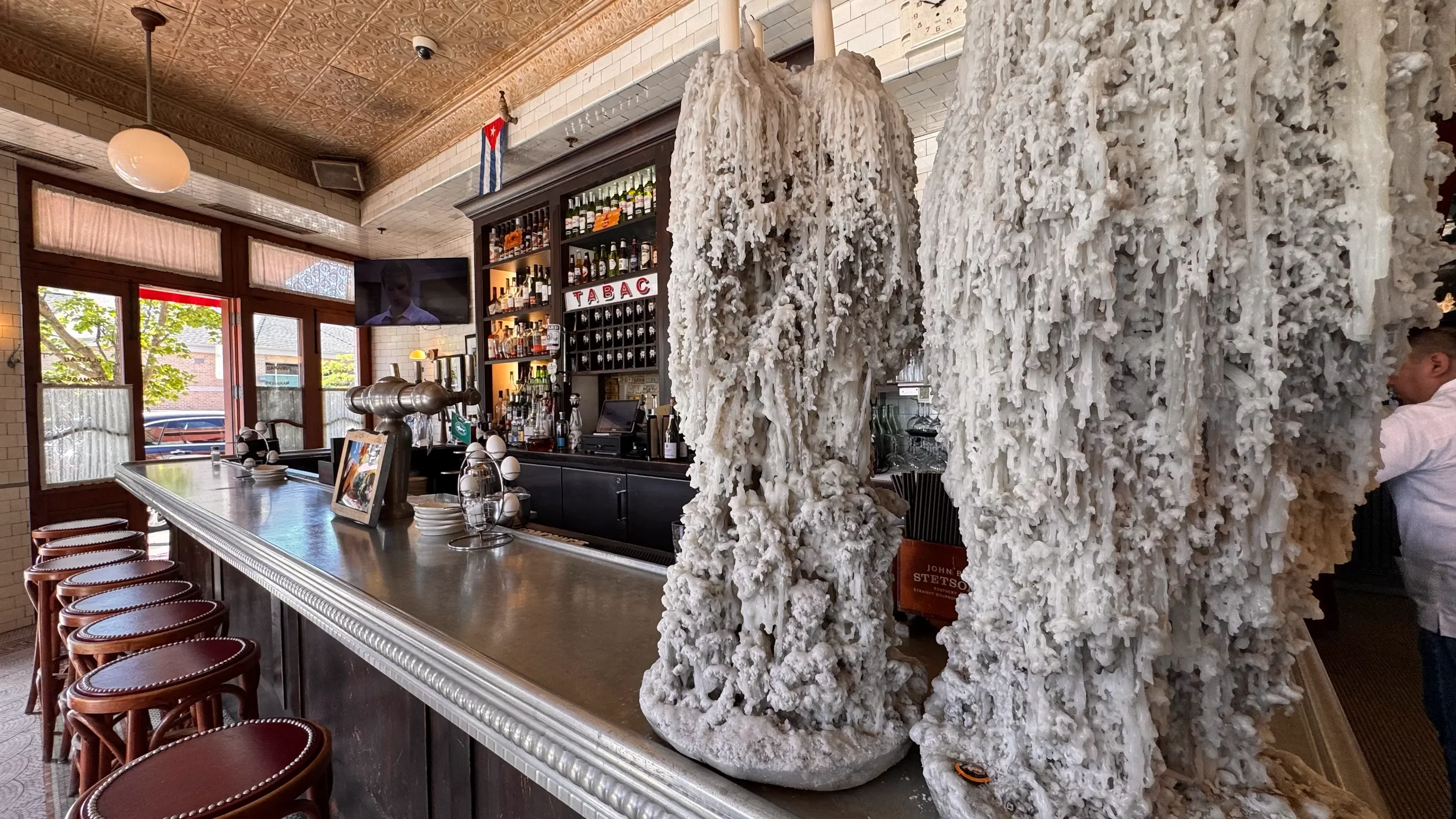 Stylish bar interior with unique candle-like decor and a well-stocked shelf