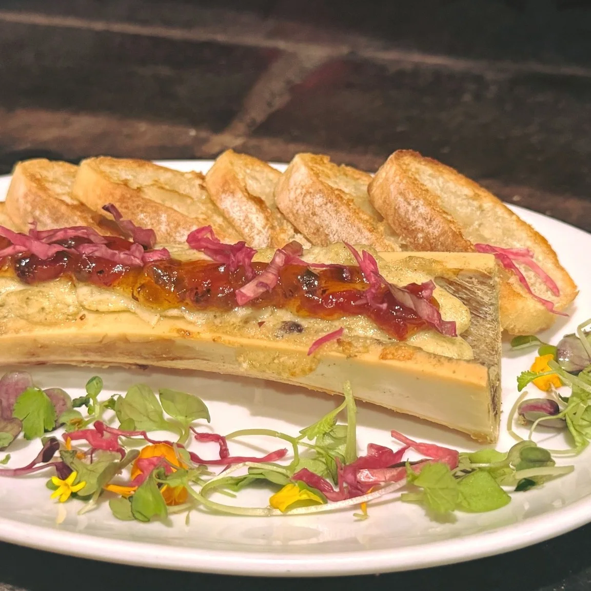 Roasted bone marrow served with crostini and microgreens