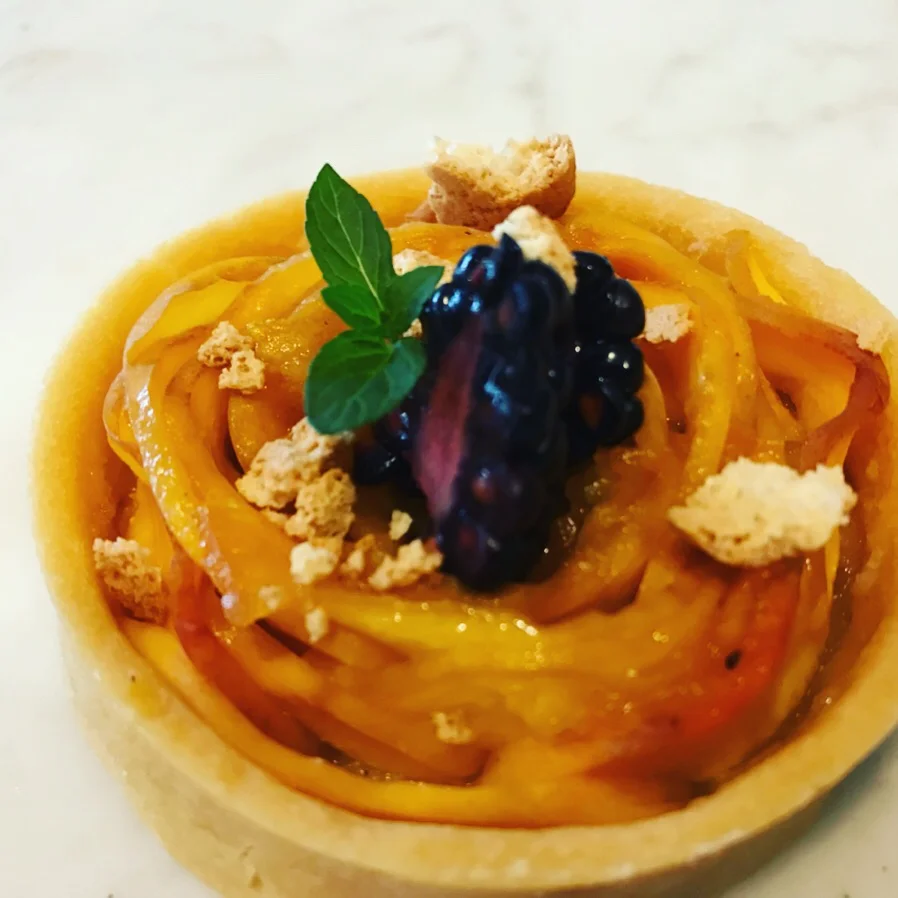 Artisan fruit tart with vibrant mango and blackberry topping