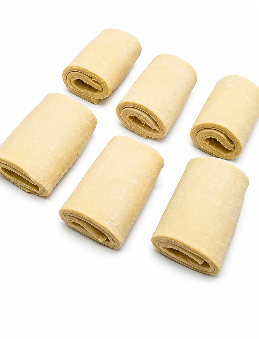 Six rolled pieces of dough on a white background.