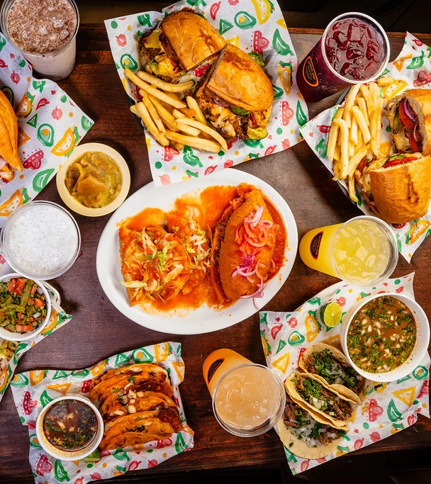 Assorted Mexican tacos and sandwiches on a colorful table