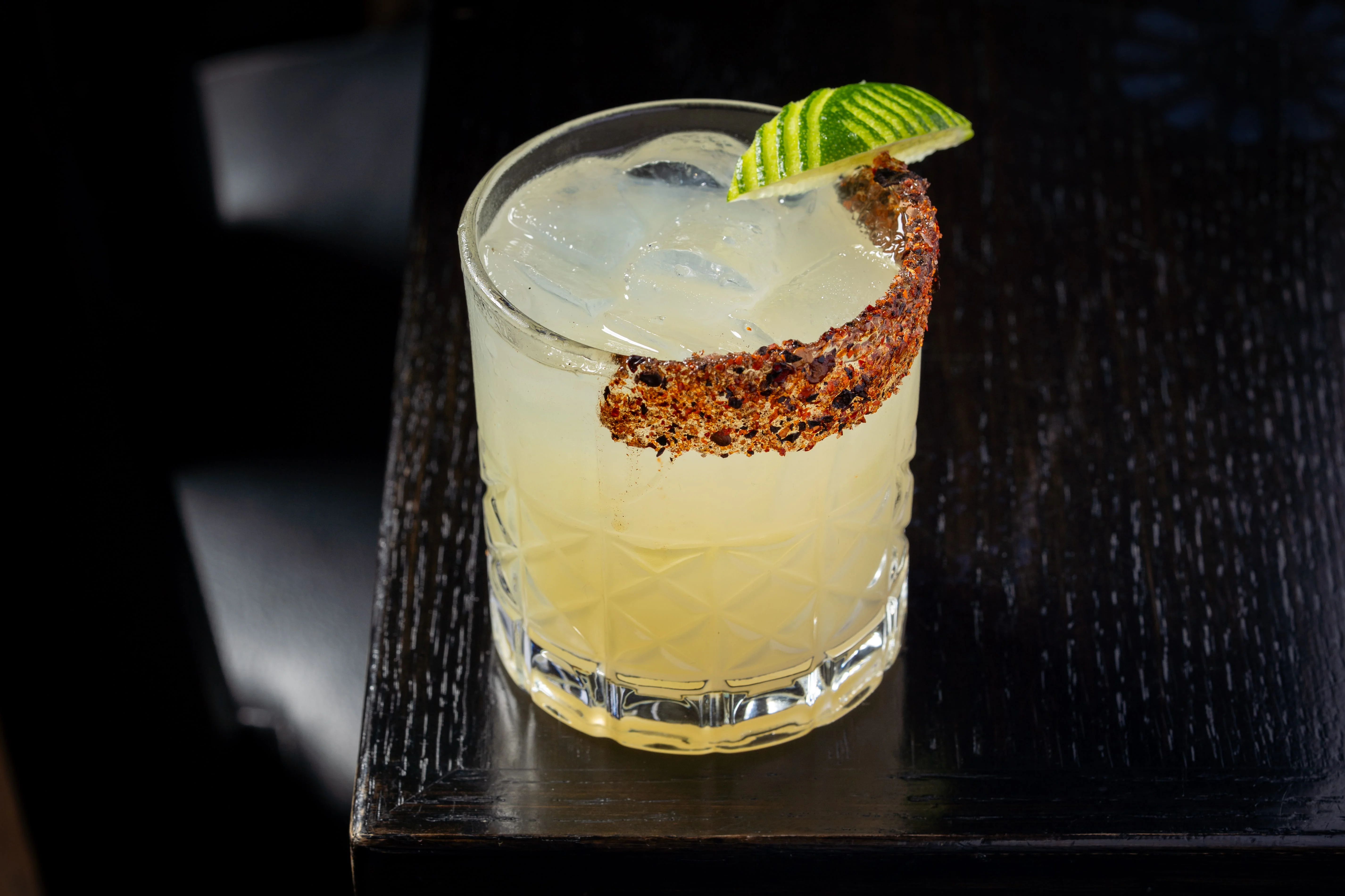 Refreshing margarita cocktail with chili rim and lime garnish