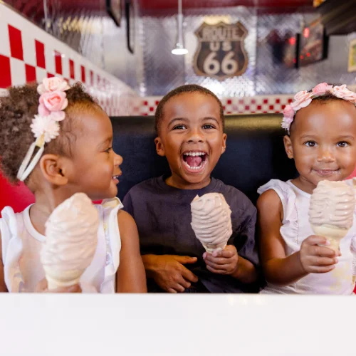 Children enjoying ice cream cones in a diner