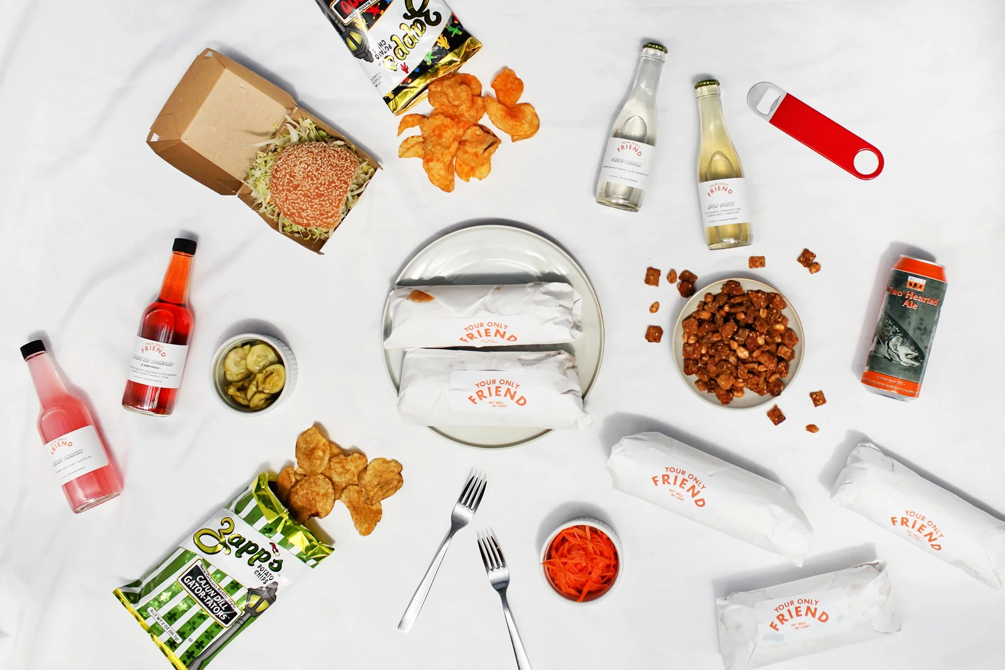Assorted dishes including Vietnamese banh mi and snacks on a white tablecloth