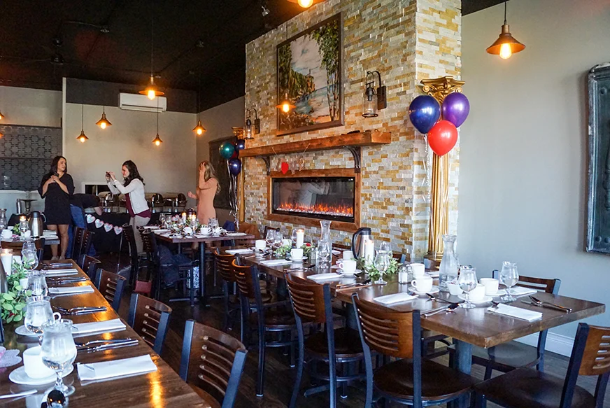 Cozy restaurant interior with wooden tables and warm lighting.