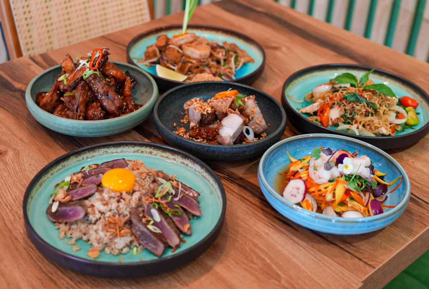 Assorted Asian dishes including noodles and rice bowls