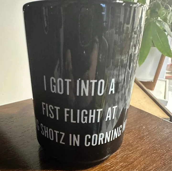 Black mug with humorous text about a bar fight