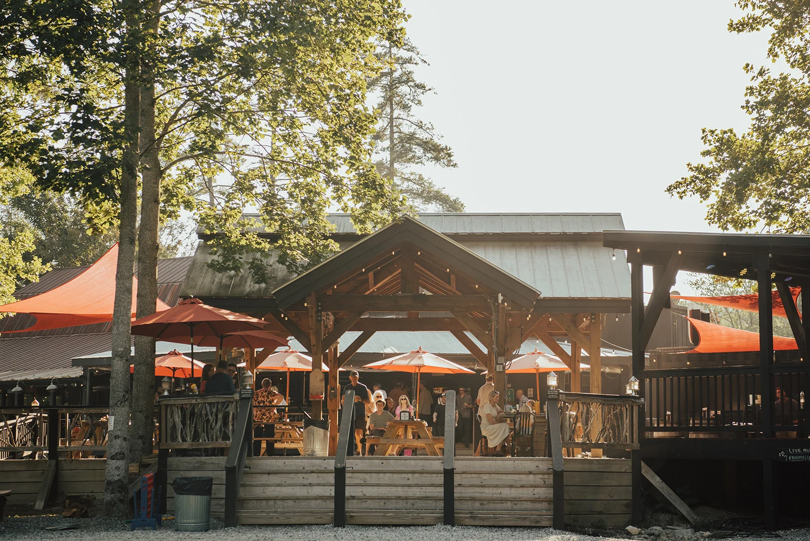 Charming black wooden restaurant with a red roof and outdoor seating