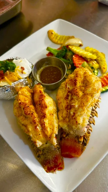 Grilled lobster tails with sides in a seafood platter
