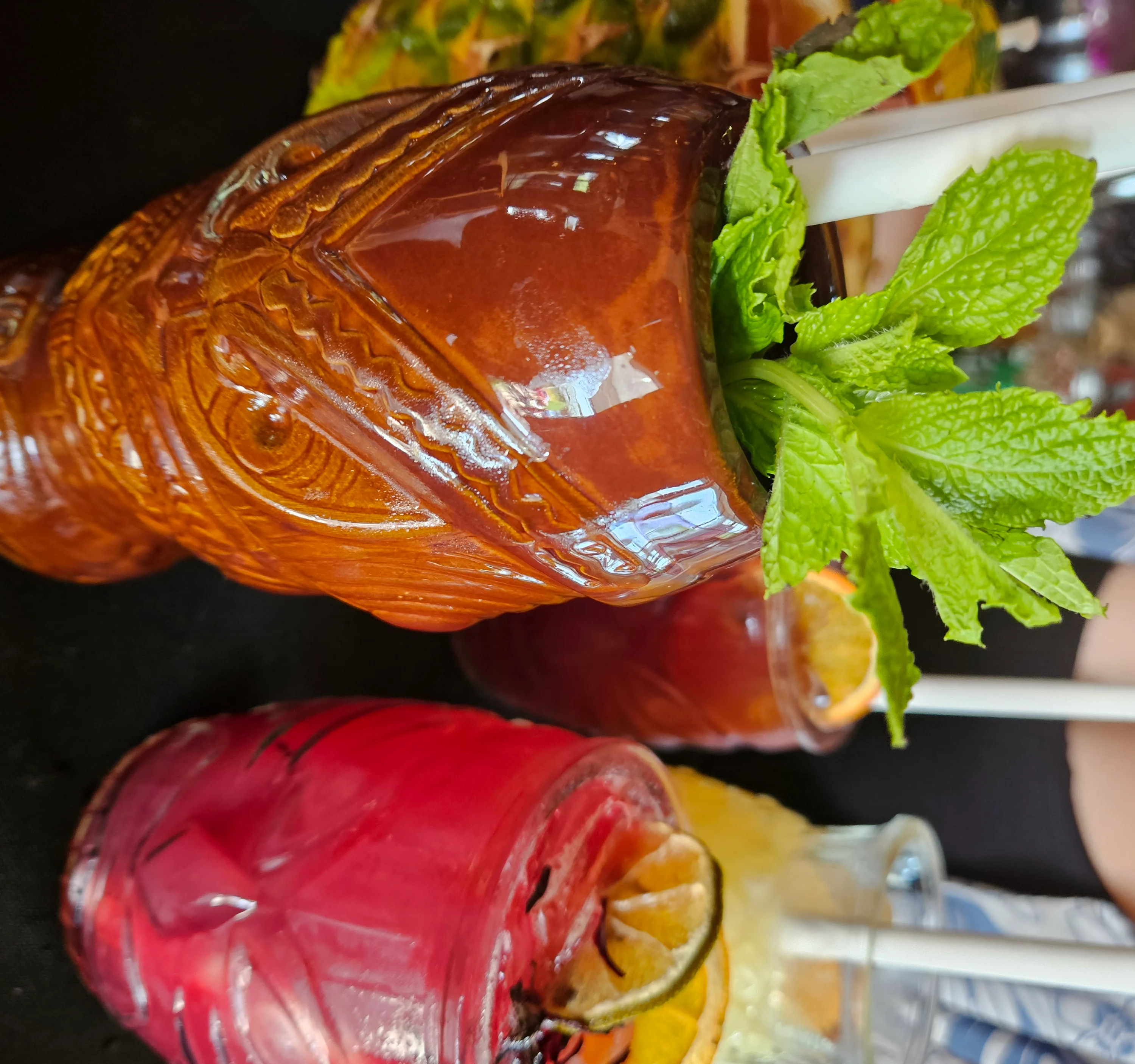 Colorful tiki cocktails with fresh mint and fruit garnishes