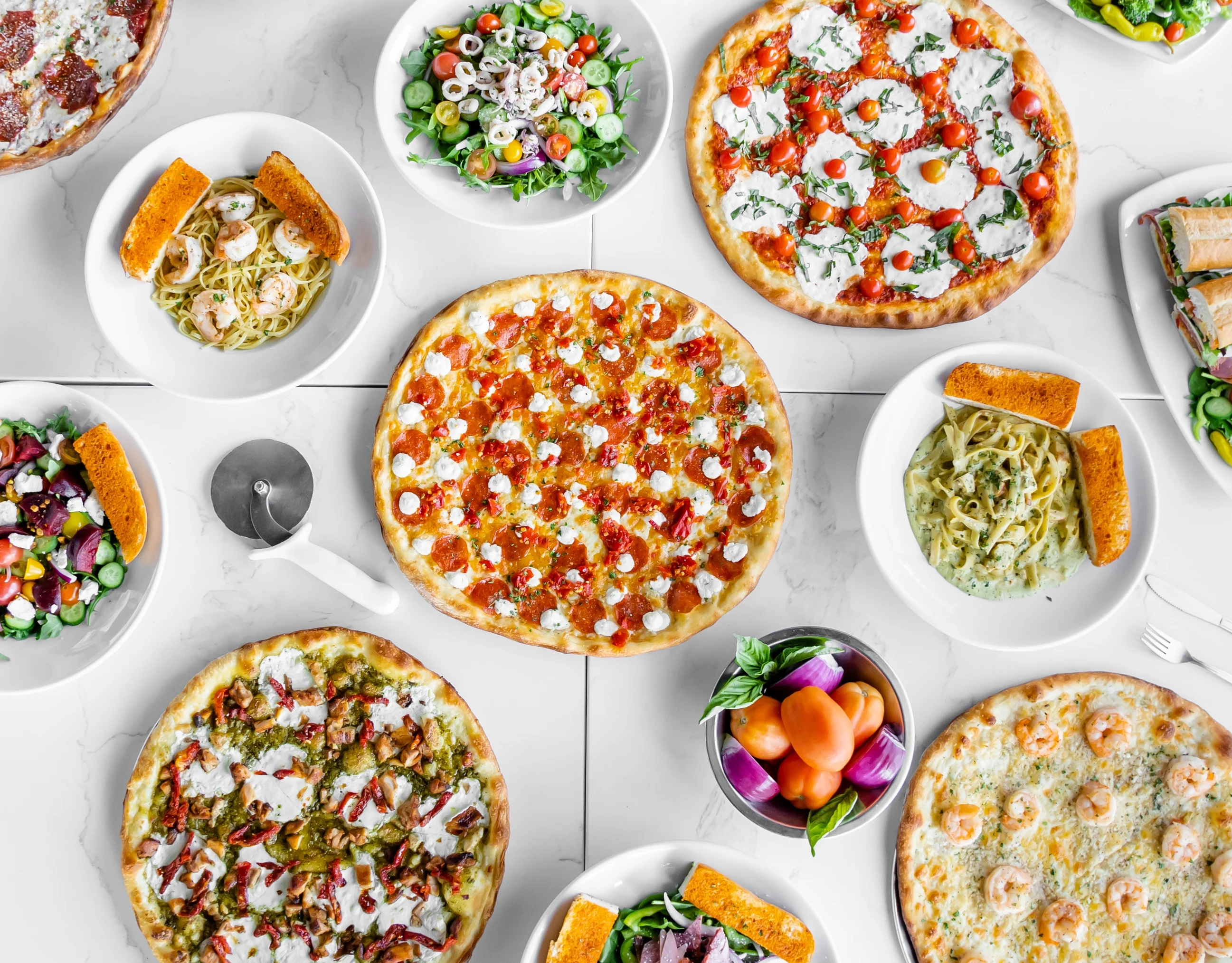 Variety of Italian pizzas and pasta dishes on a dining table