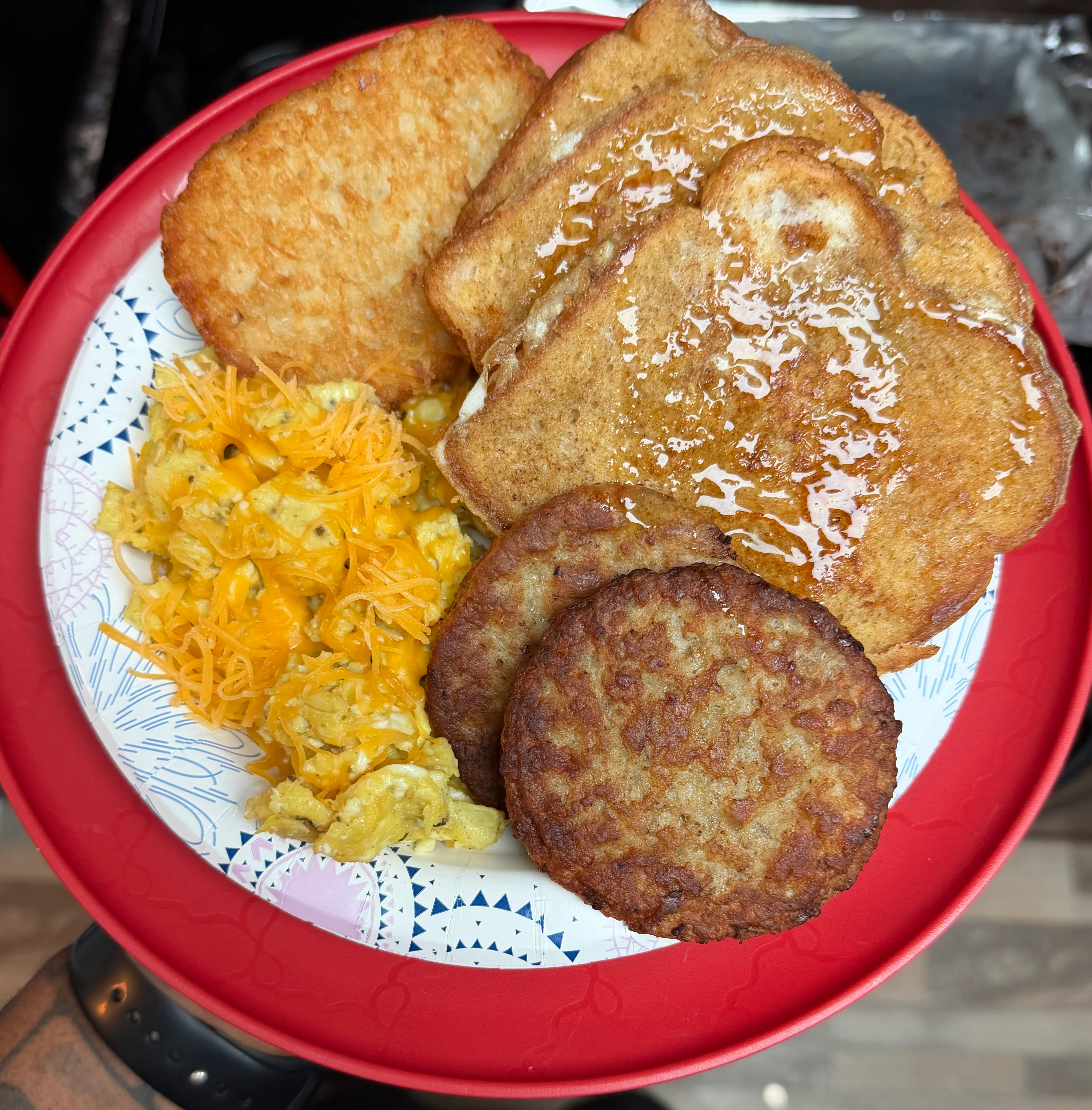 Plate of French toast, scrambled eggs with cheese, and sausage patties.