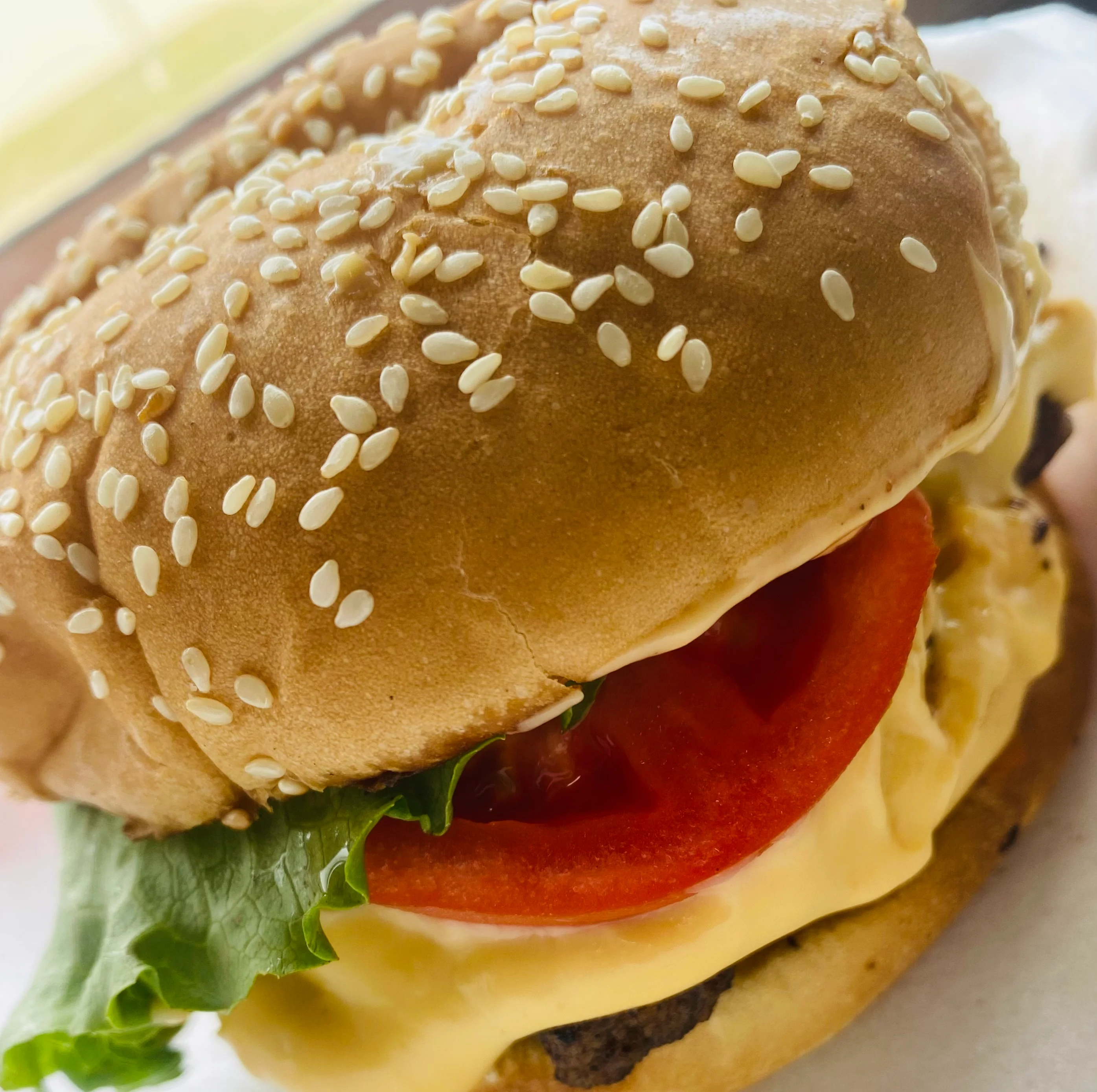 A food container filled with BBQ wings, crinkle-cut fries drizzled with sauce, and a slice of toasted bread with lettuce and tomato.
