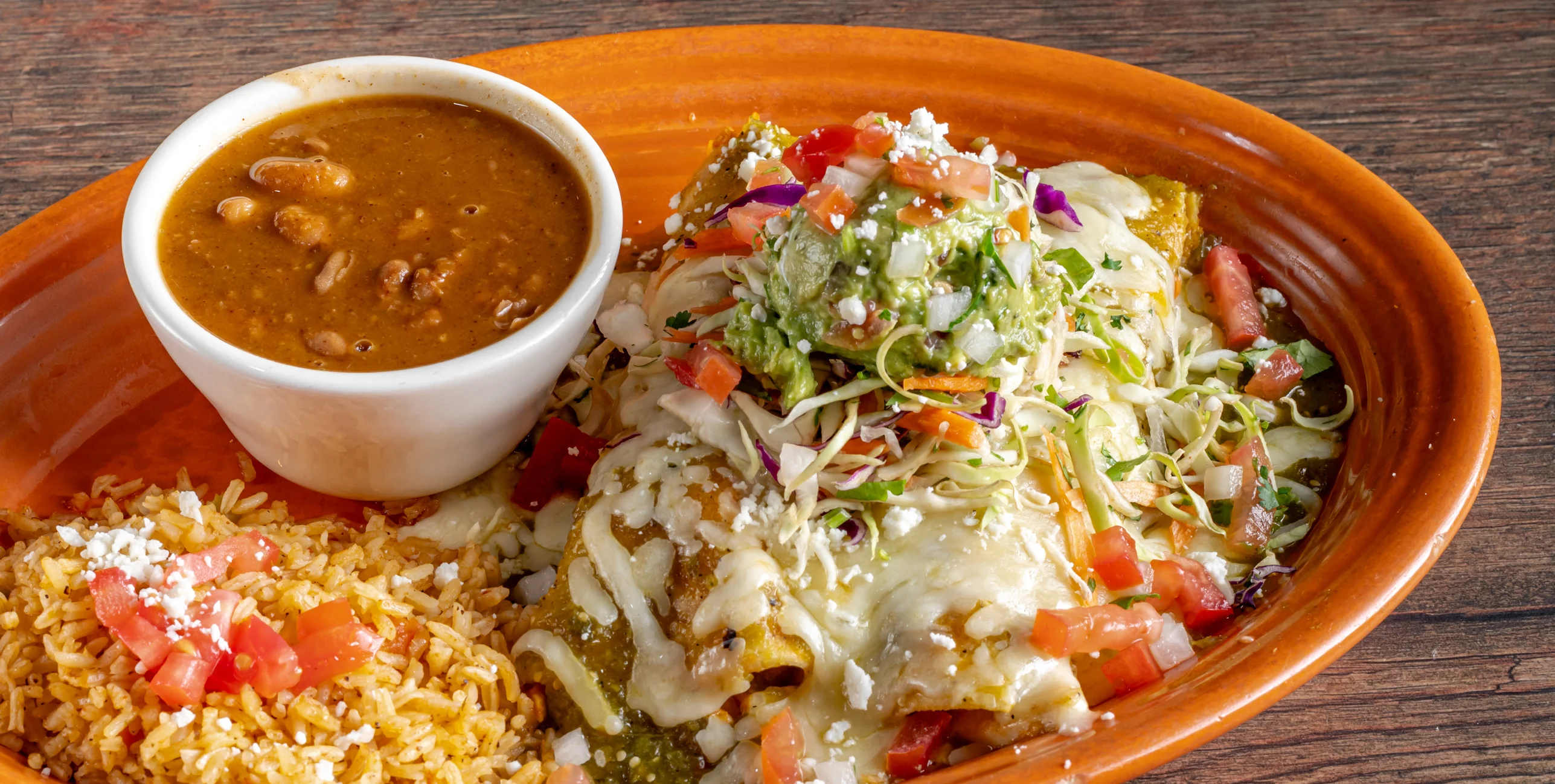 Plate of enchiladas with rice and beans in a Mexican restaurant