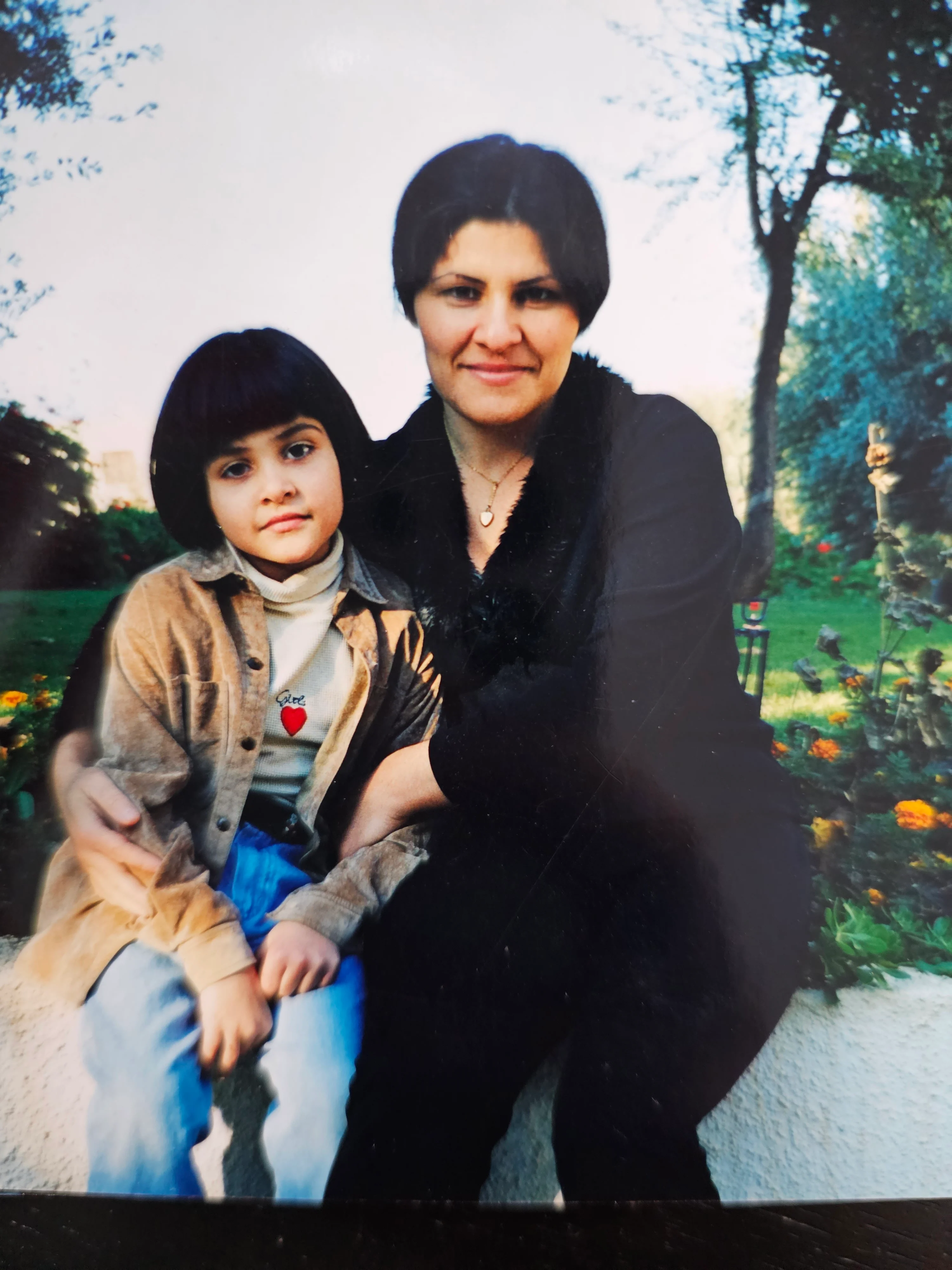 Mother and daughter posing together in a garden setting