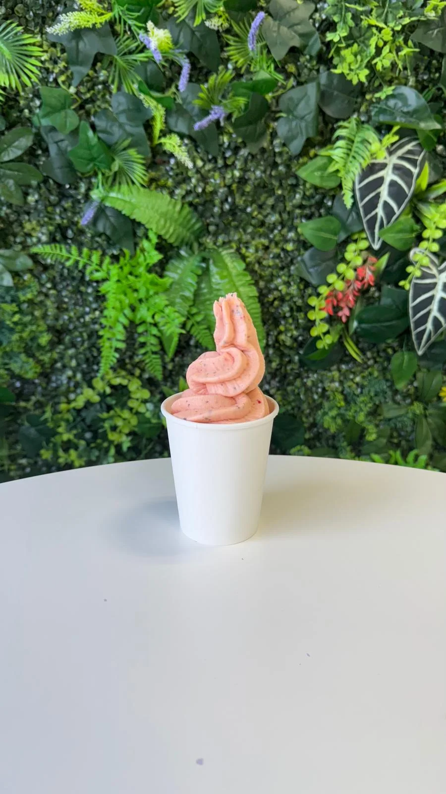 Creamy strawberry soft serve in a cup