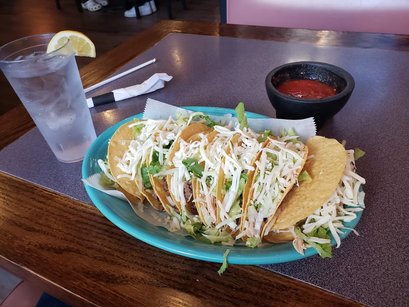 Plate of crispy tacos with shredded chicken and lettuce