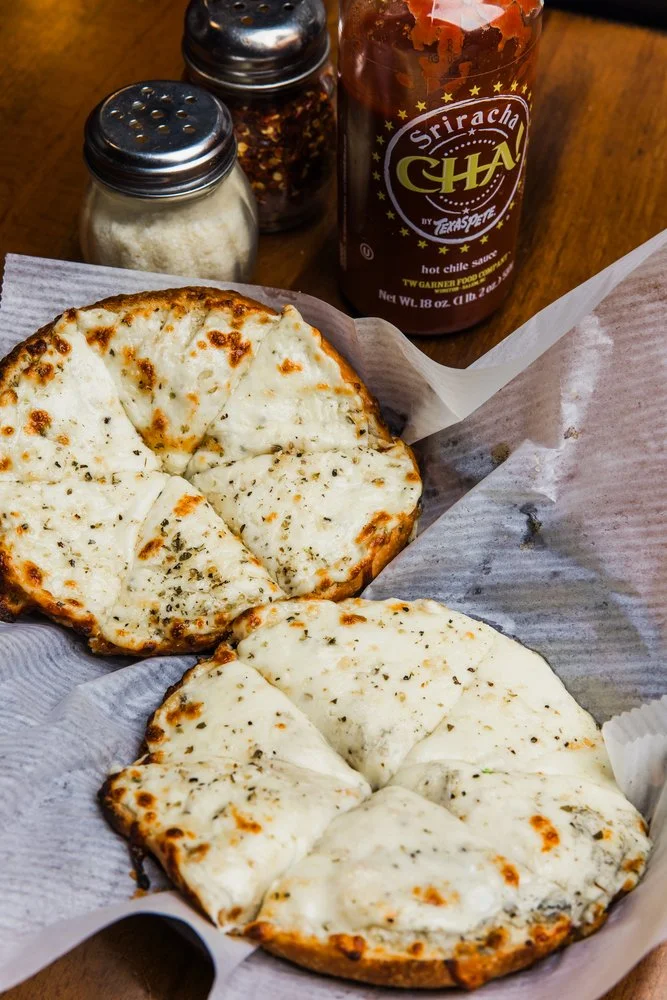 Cheesy garlic bread with herbs served in a casual dining setting