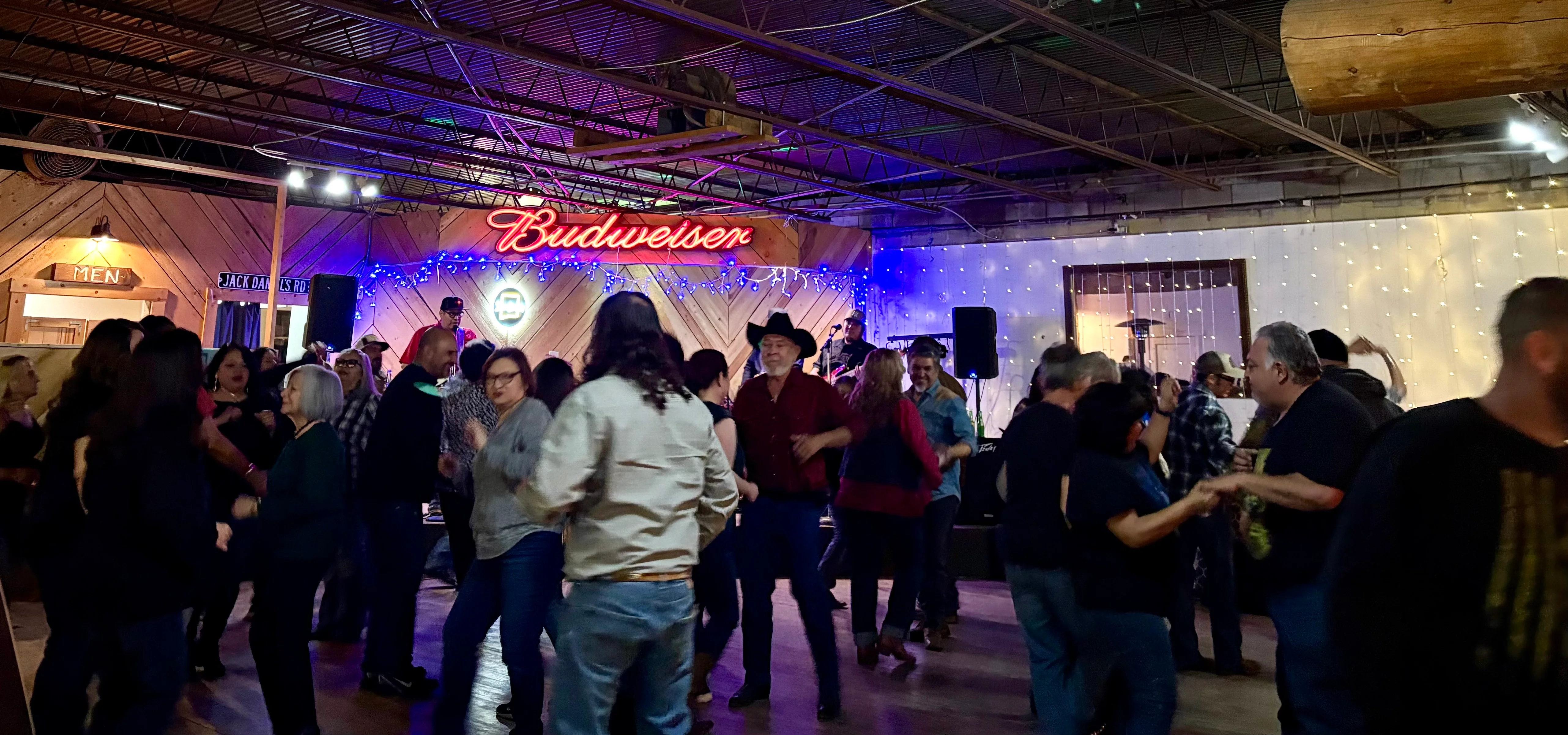 Lively dance floor at a country music venue with neon lights