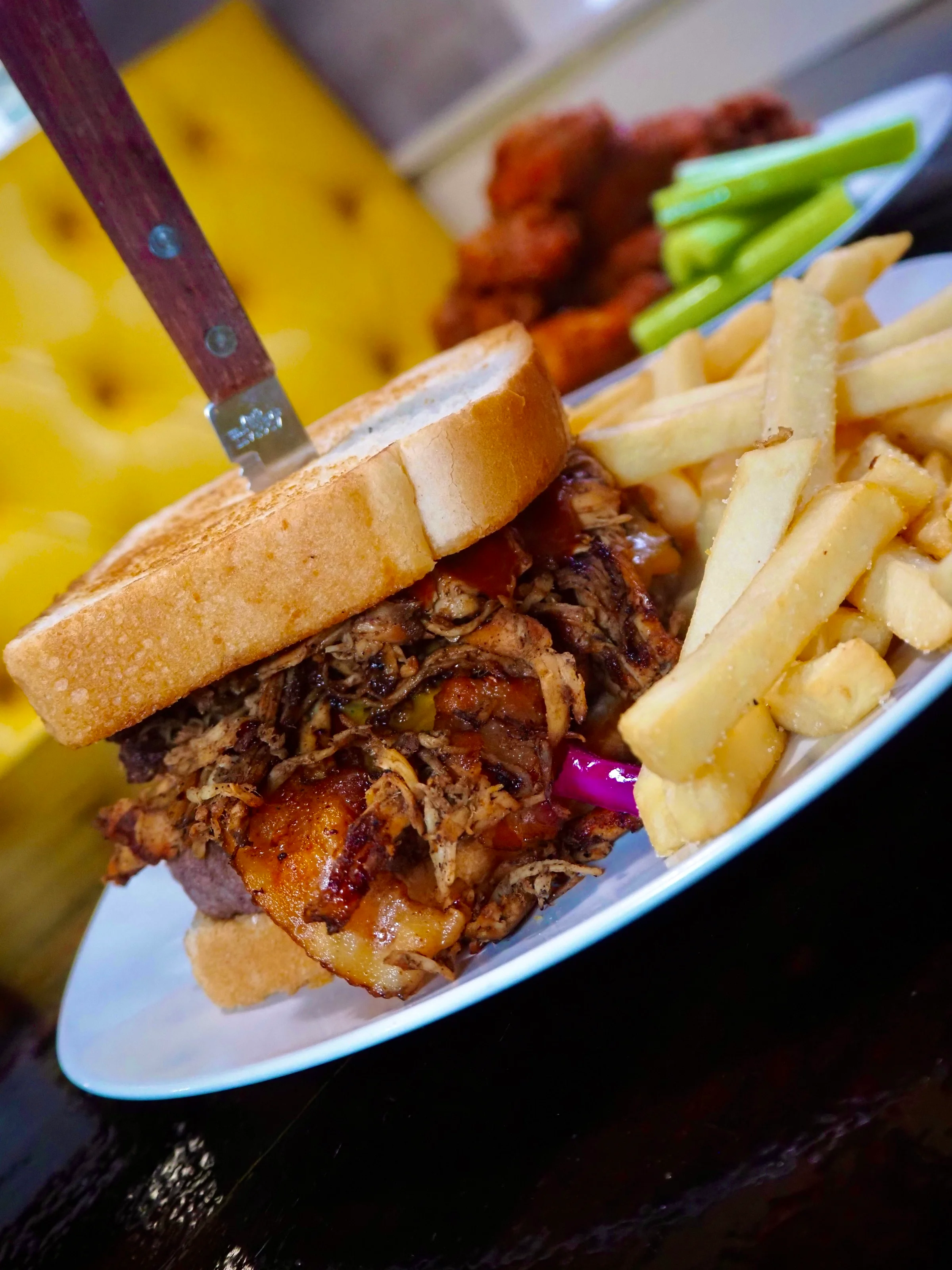 Pulled pork sandwich with fries and celery sticks