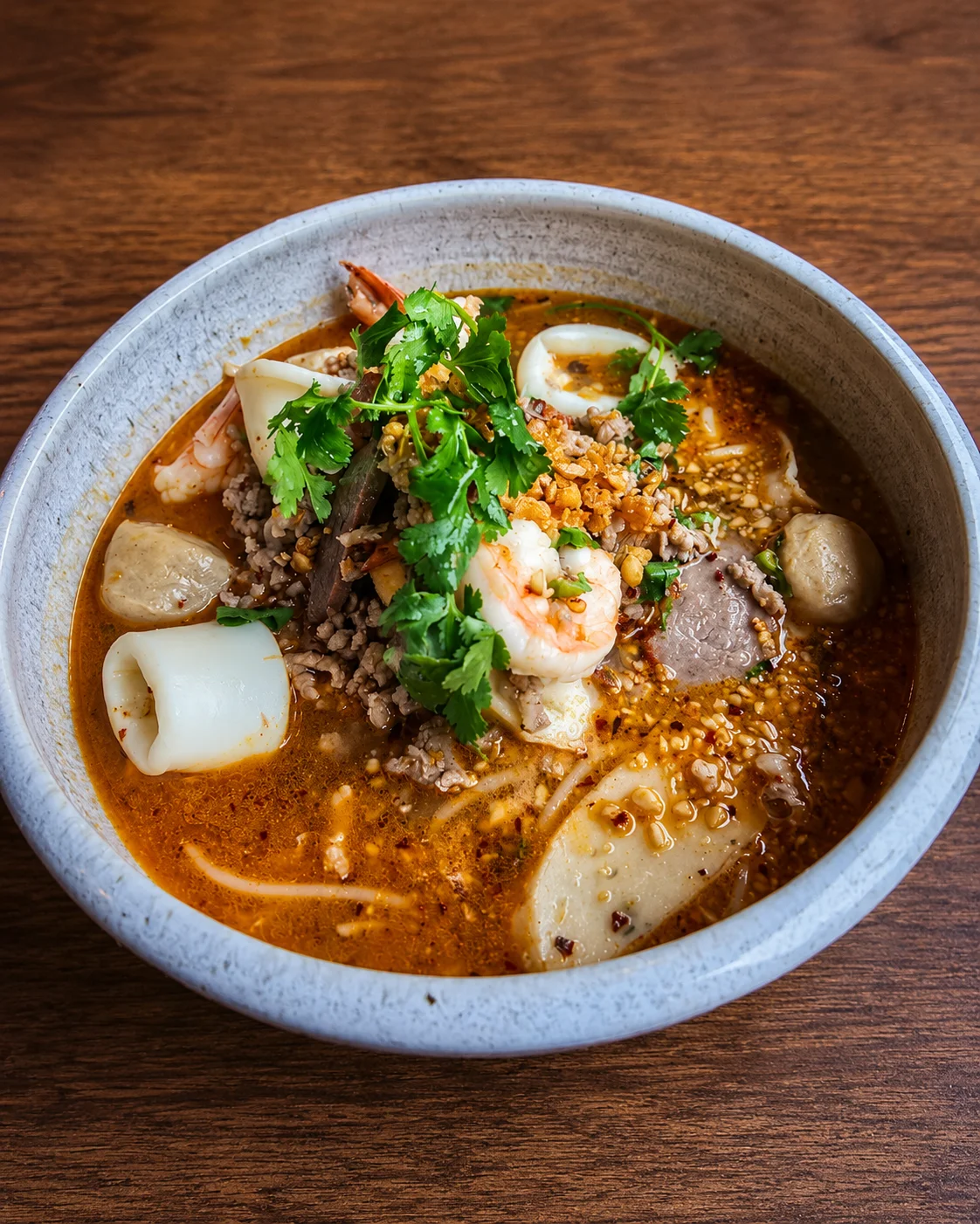 Spicy Thai boat noodles with seafood and herbs