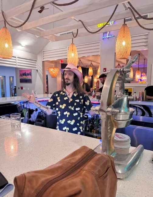 Bartender in a tropical-themed bar with colorful decor