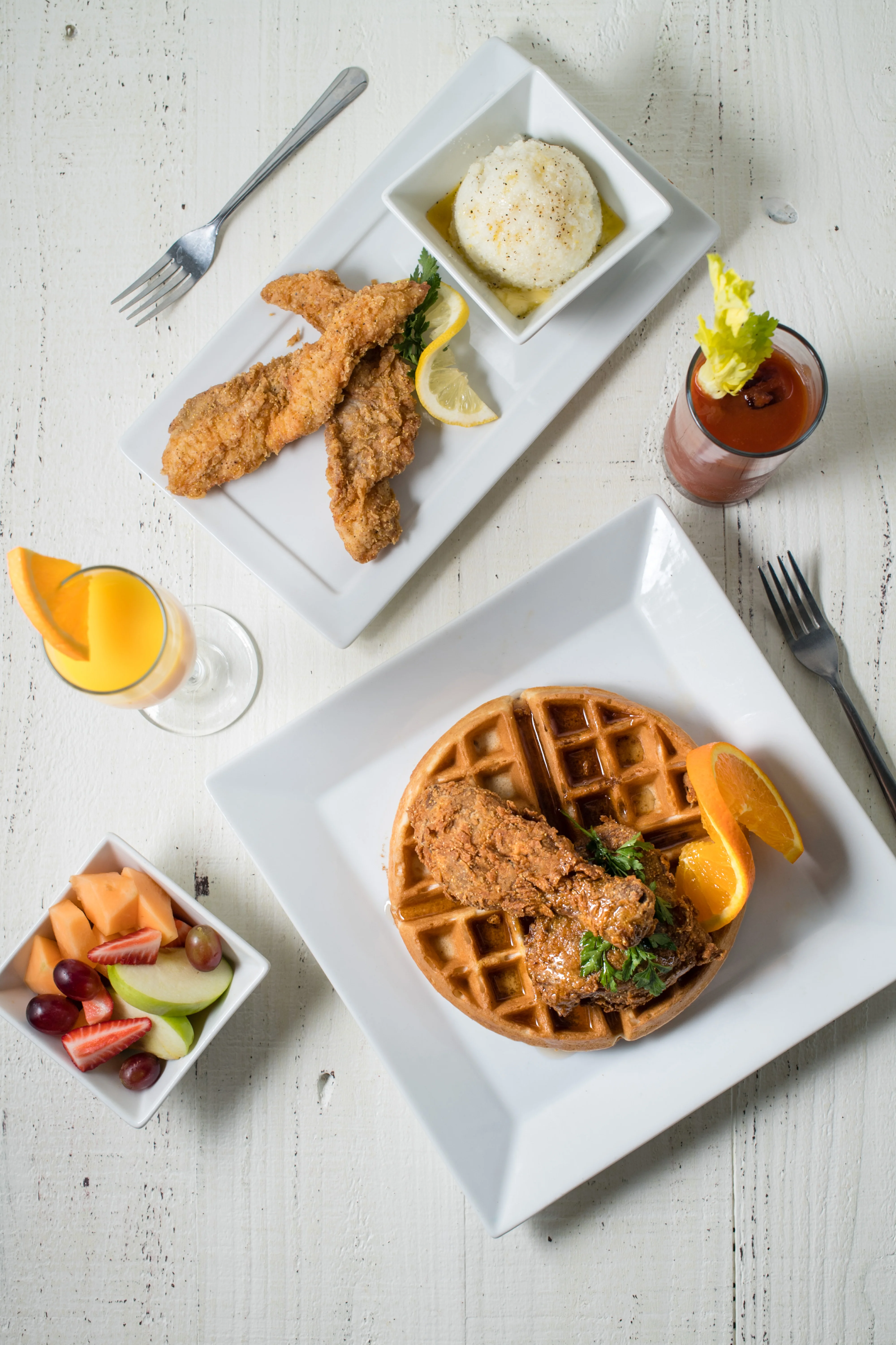 Southern-style chicken and waffles with fruit and cocktails