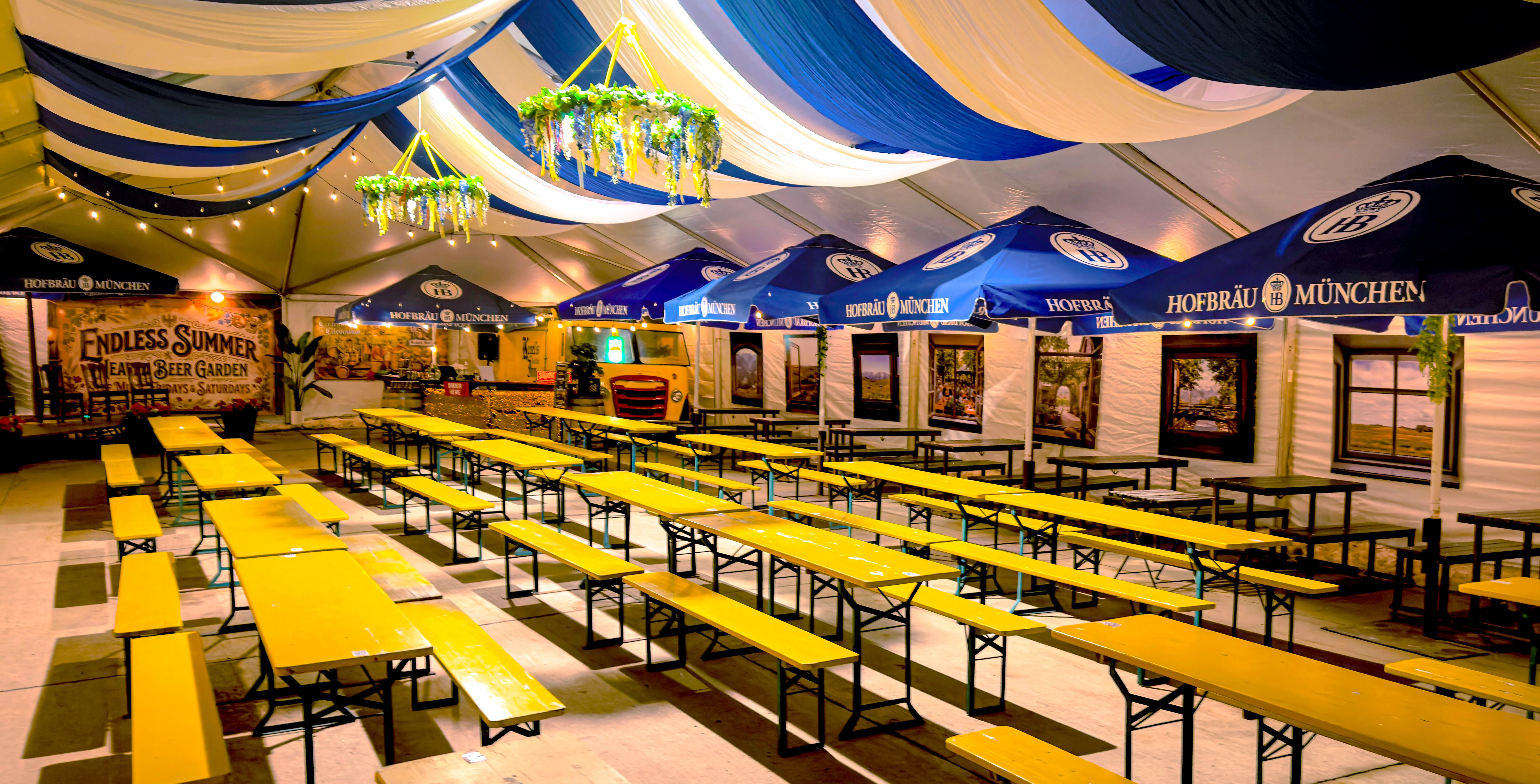 Spacious beer garden with yellow tables and festive decor
