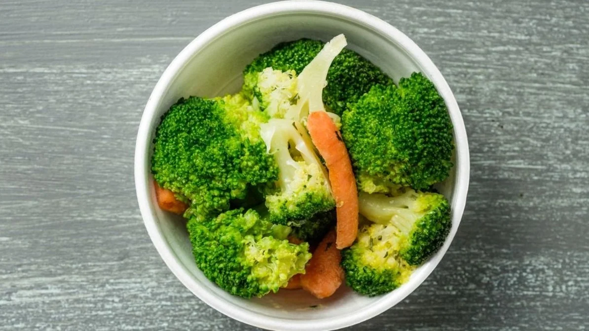 Steamed vegetables from VooDoo BBQ in Pensacola featuring broccoli, carrots, and herb garlic butter.