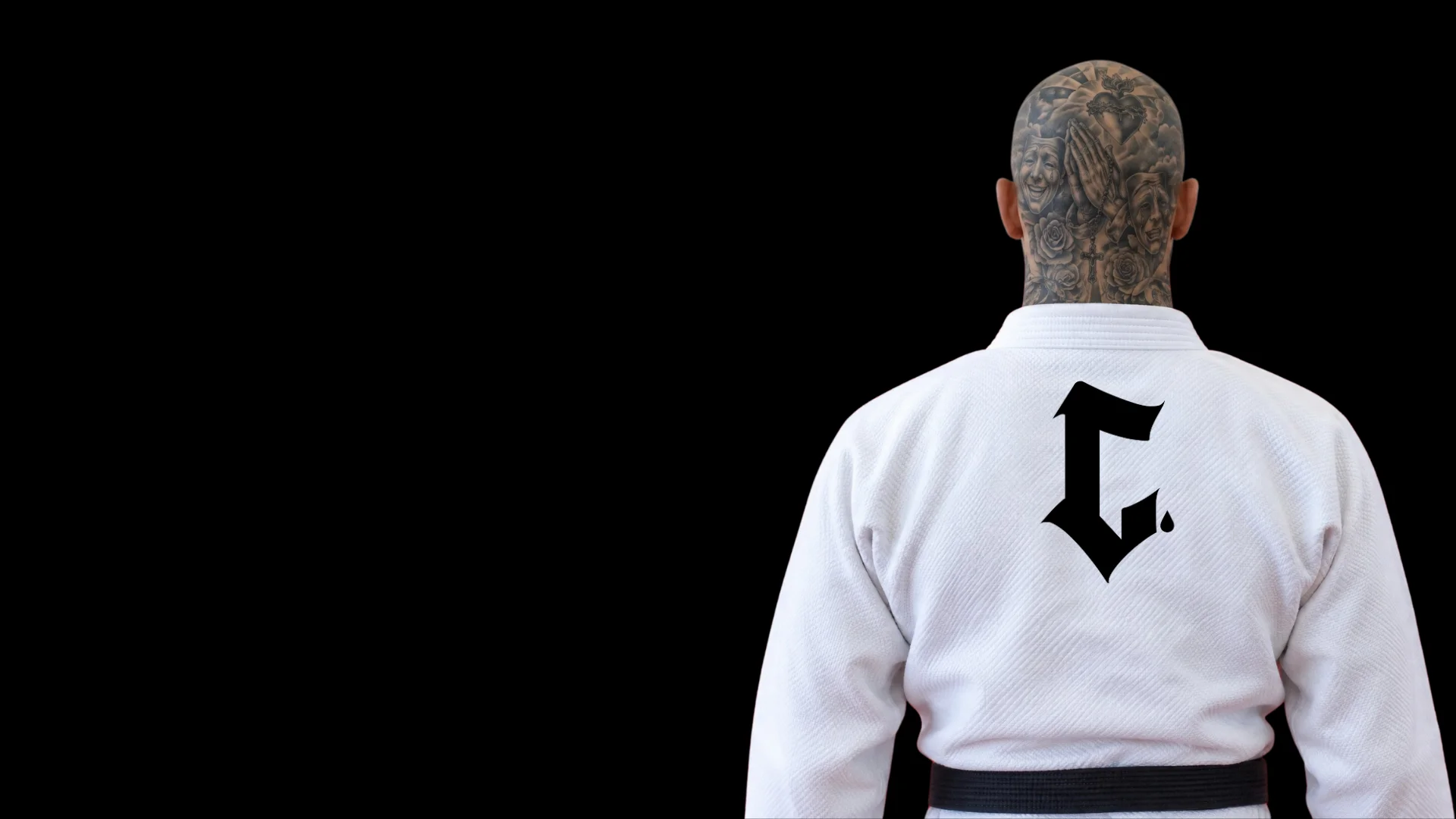 Martial artist in a white gi with intricate tattoos on the back of the head