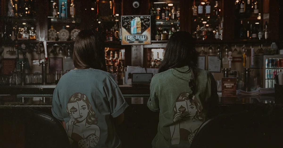 Two patrons seated at a dimly lit restaurant bar