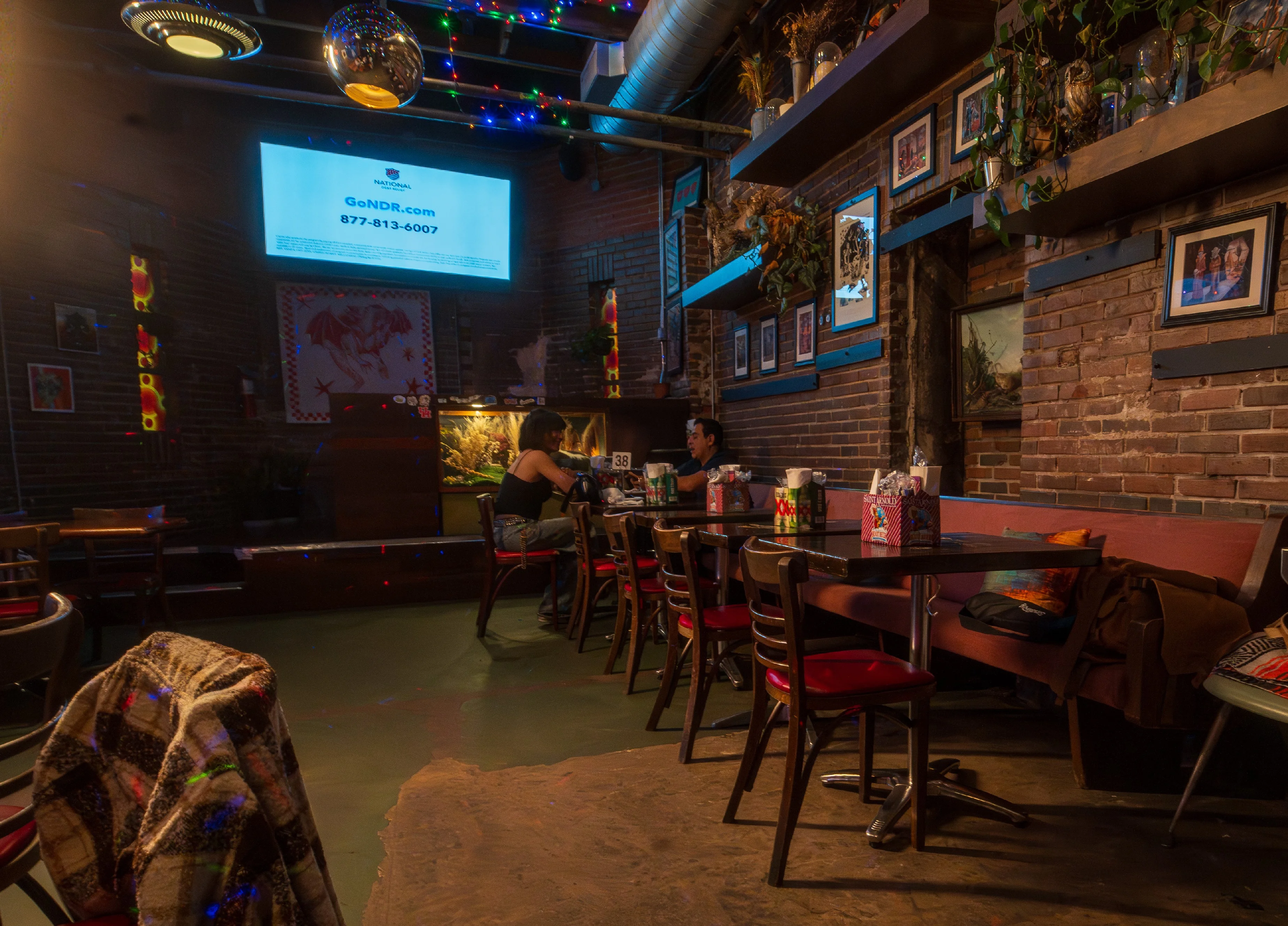 Cozy restaurant interior with colorful lights and brick walls