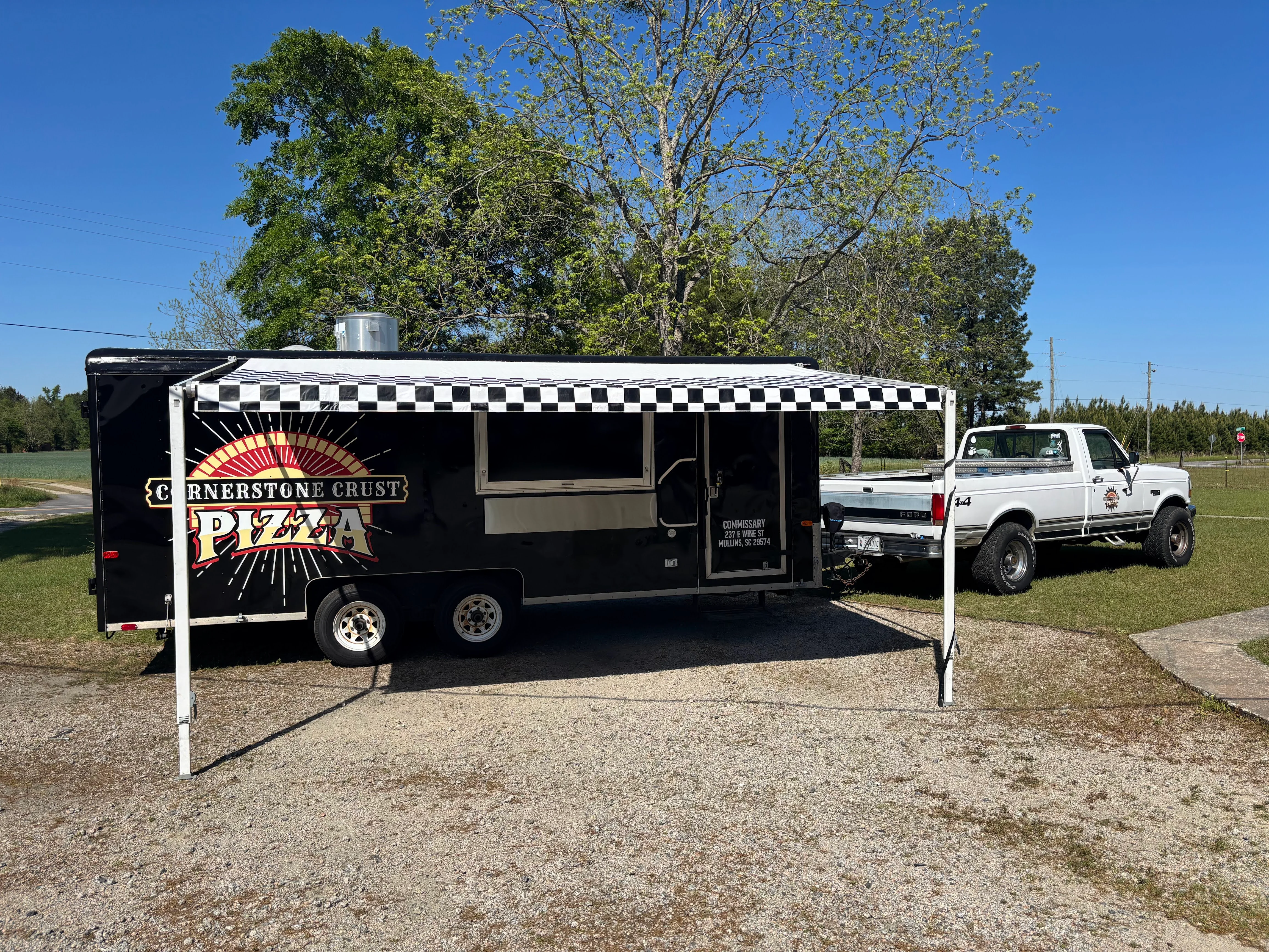 Mobile pizza food truck with checkered awning