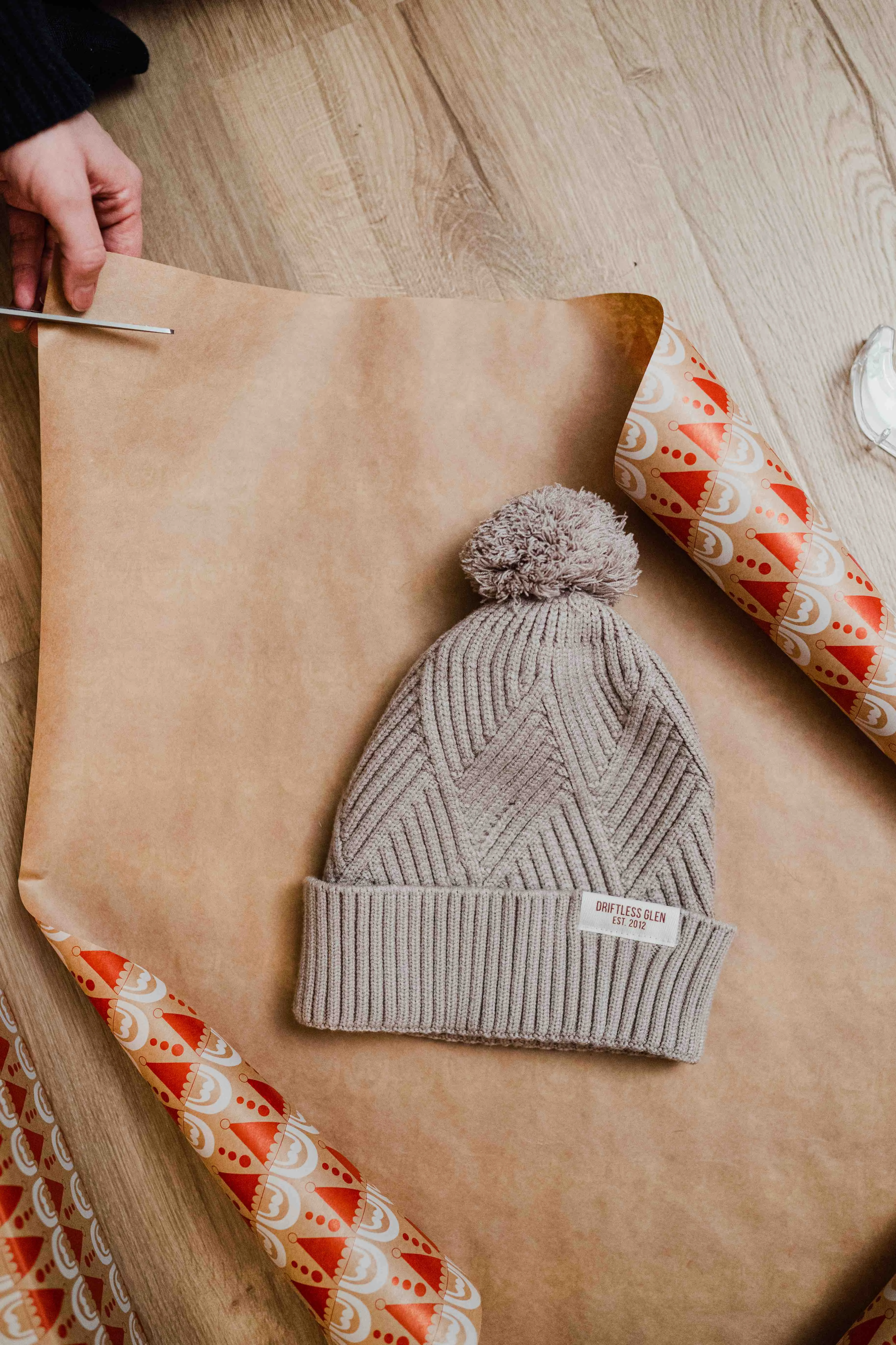 Tan Beanie on holiday wrapping paper being wrapped up