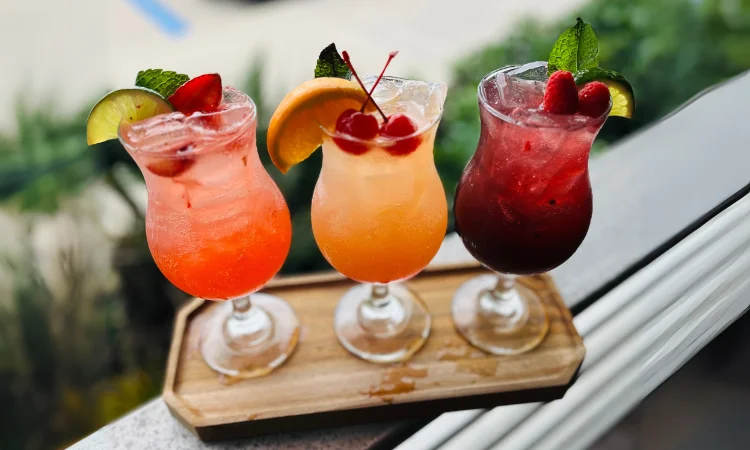 Colorful tropical cocktails on a wooden tray