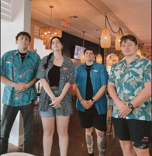 Staff members in tropical shirts at a vibrant restaurant interior