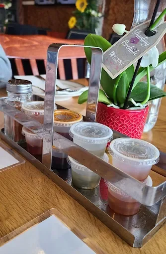 Variety of colorful sauces in a metal holder at a restaurant table