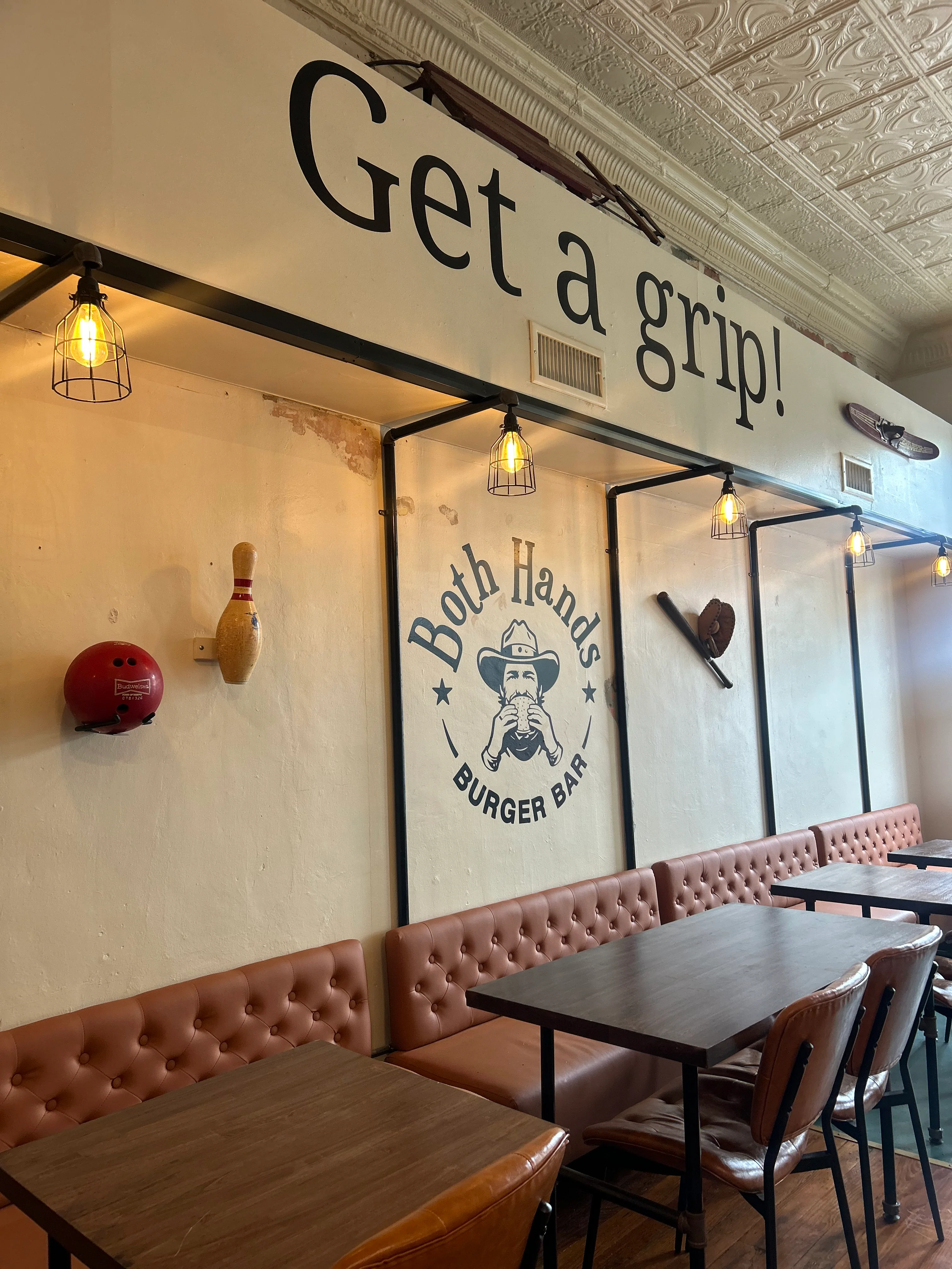 An interior view of a burger bar with a playful slogan, comfortable seating, and stylish decor.