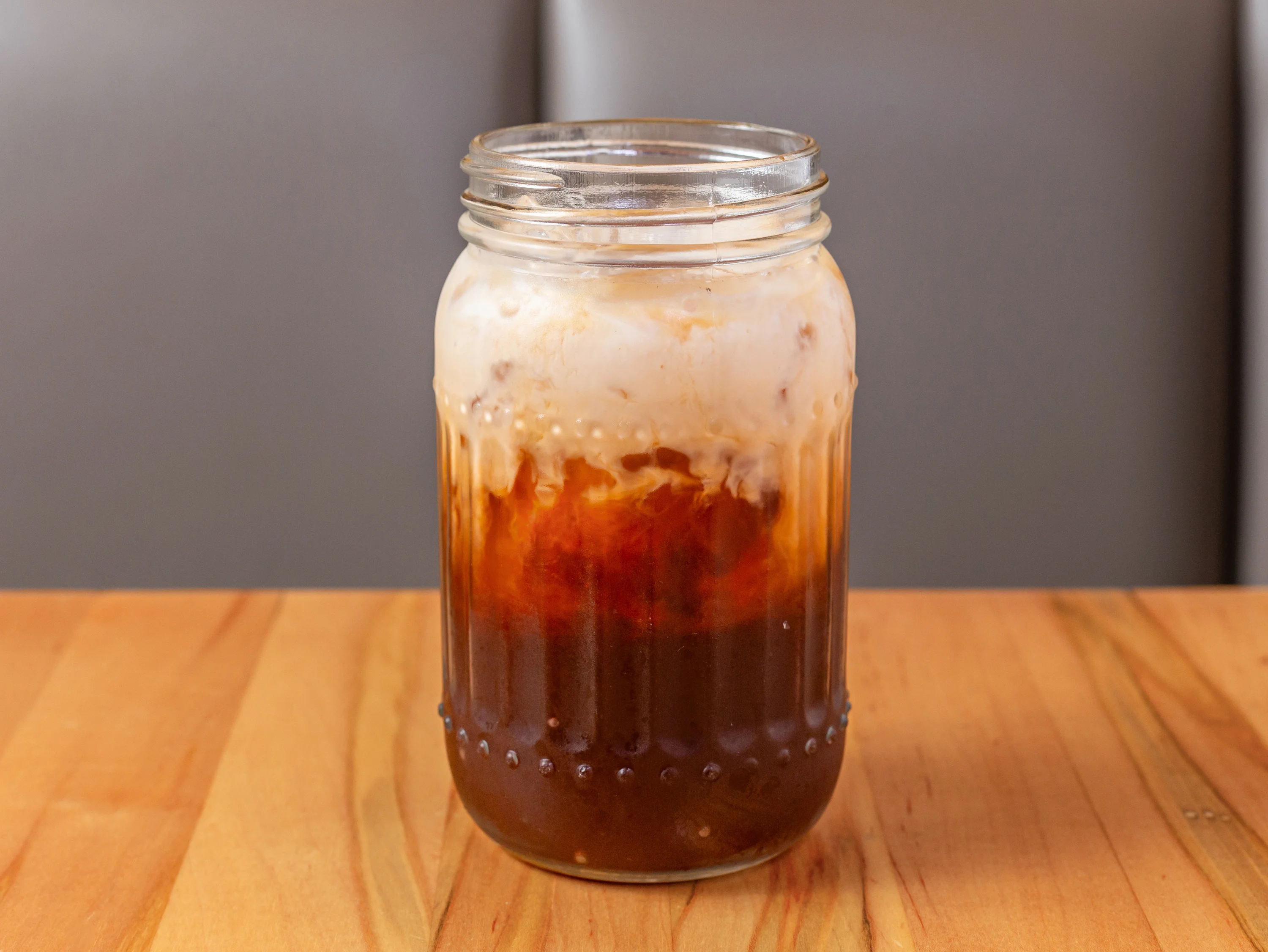 Iced coffee with cream in a glass jar