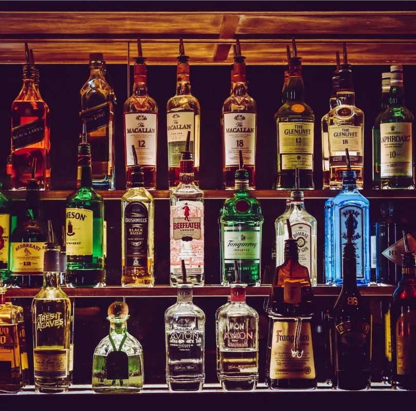 Well-stocked bar shelf with various liquor bottles