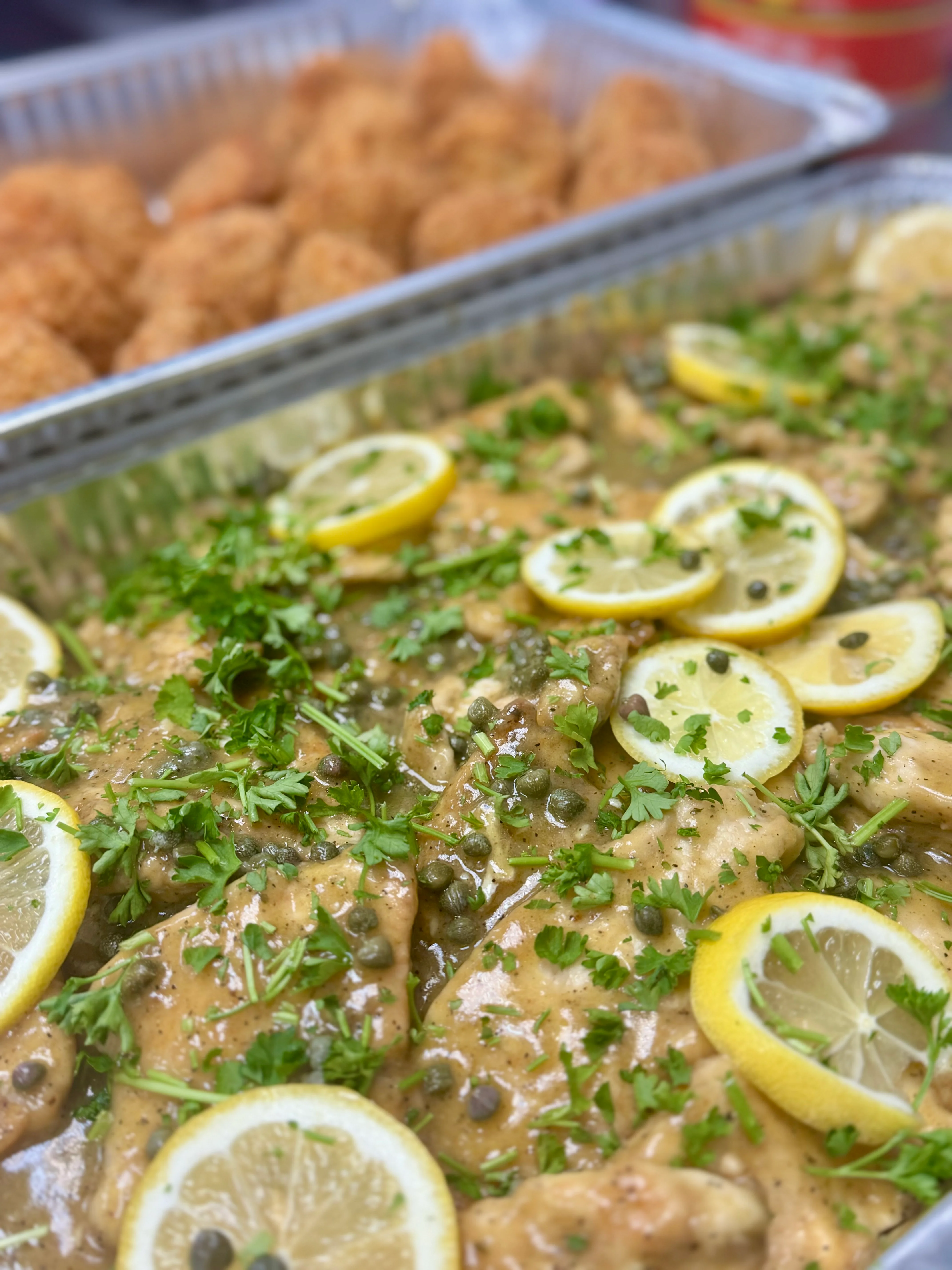 Plate of chicken piccata garnished with lemon and parsley.