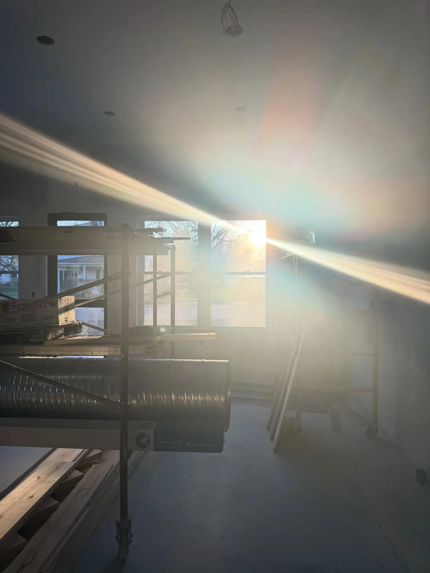 Sunlight streaming through a construction site with scaffolding and tools