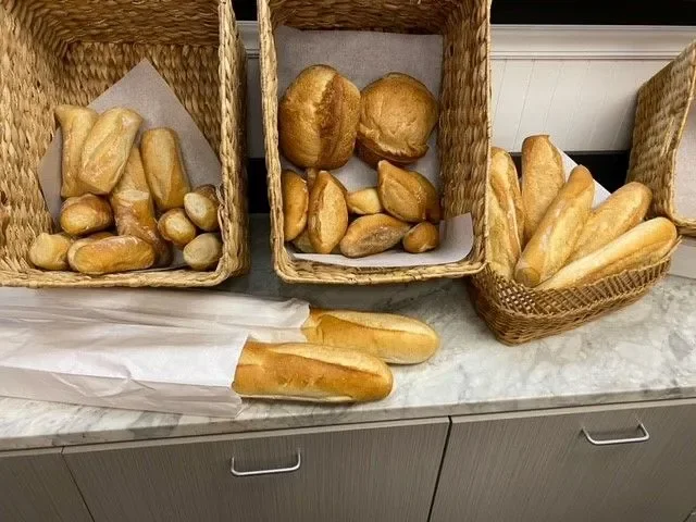 Assorted fresh French bread loaves in woven baskets