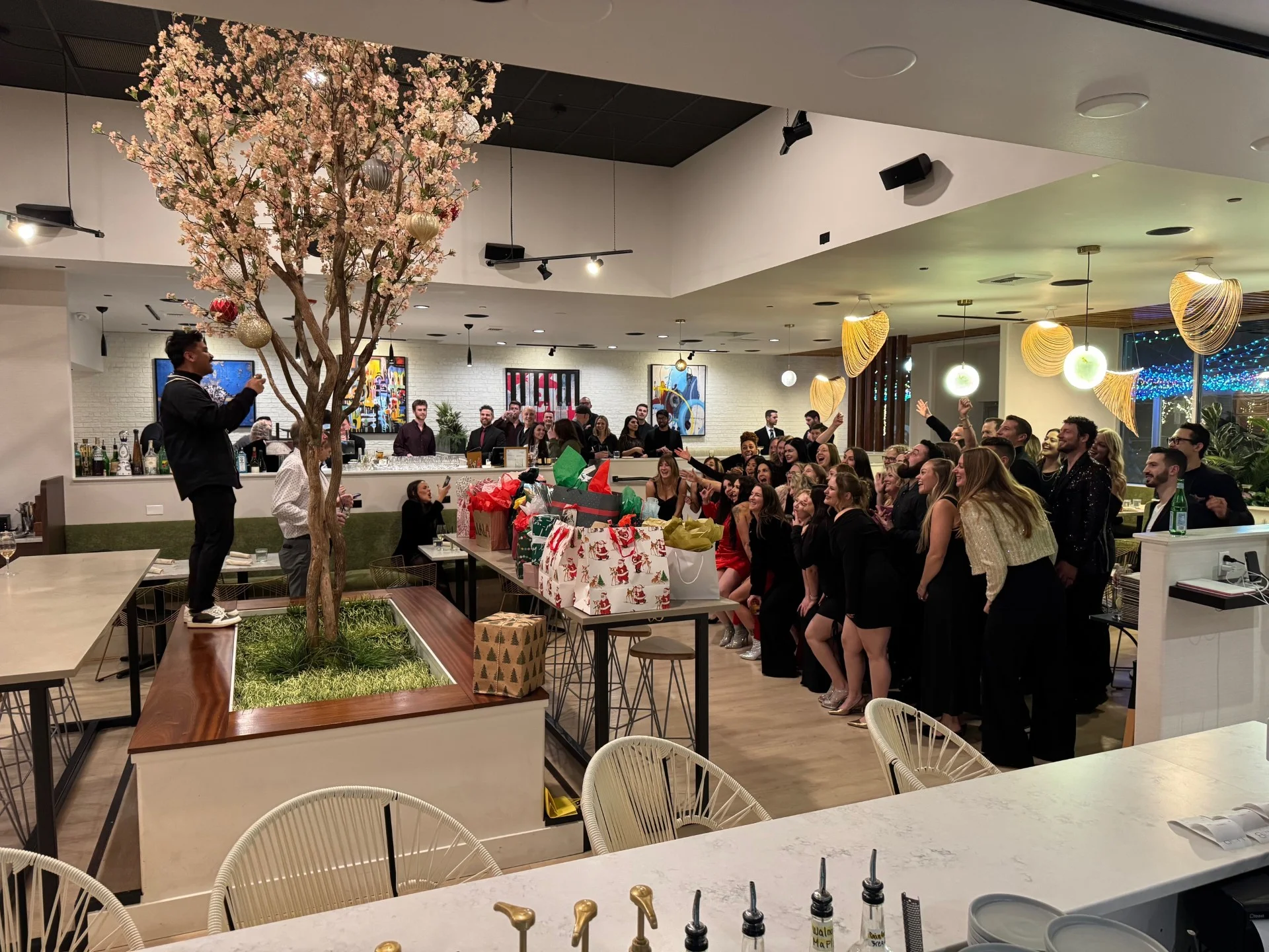 Festive restaurant gathering with guests celebrating and exchanging gifts