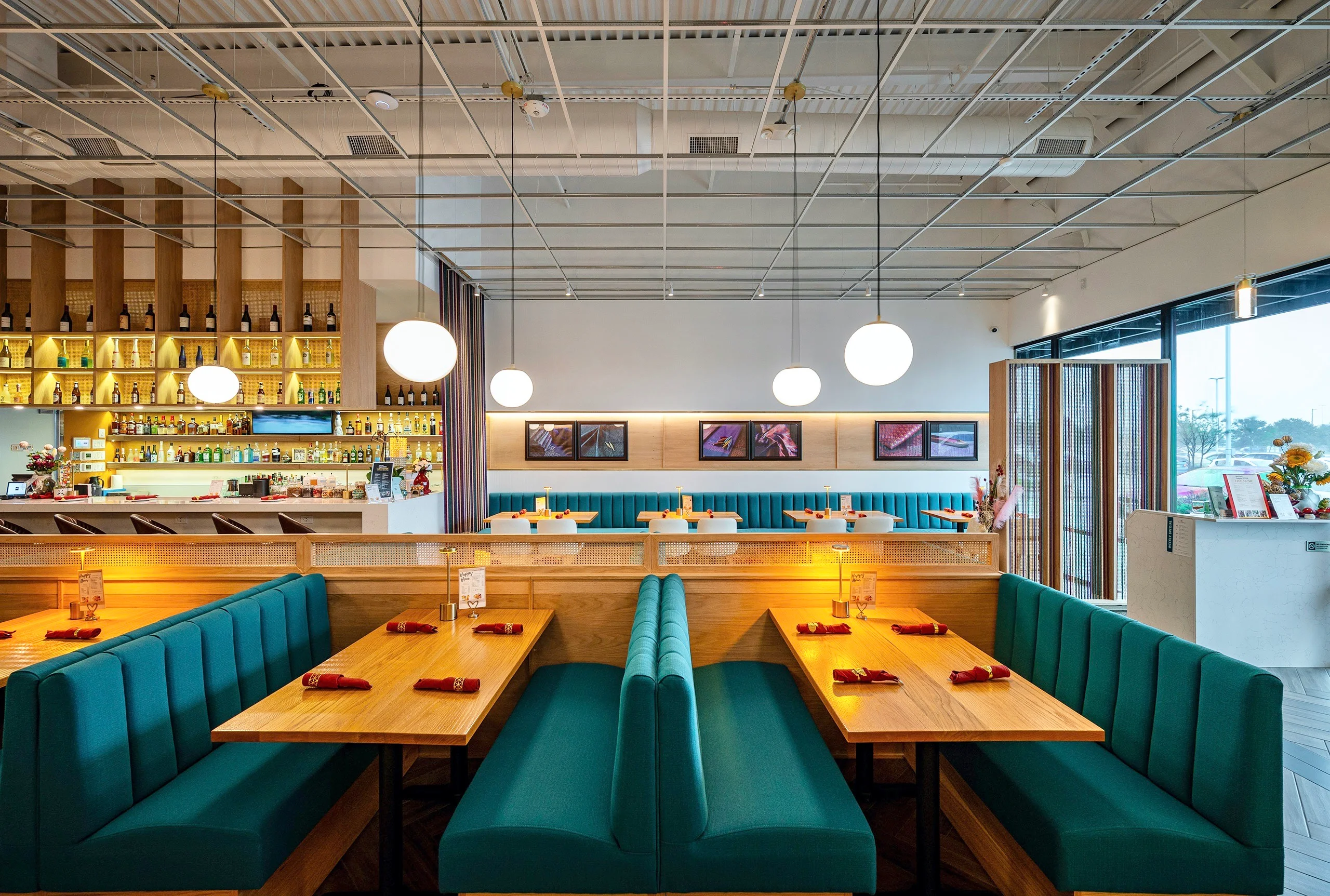 Modern restaurant interior with teal seating and warm lighting