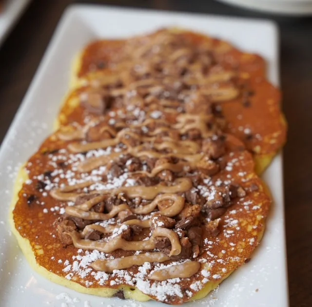 Fluffy pancakes topped with chocolate and peanut butter drizzle