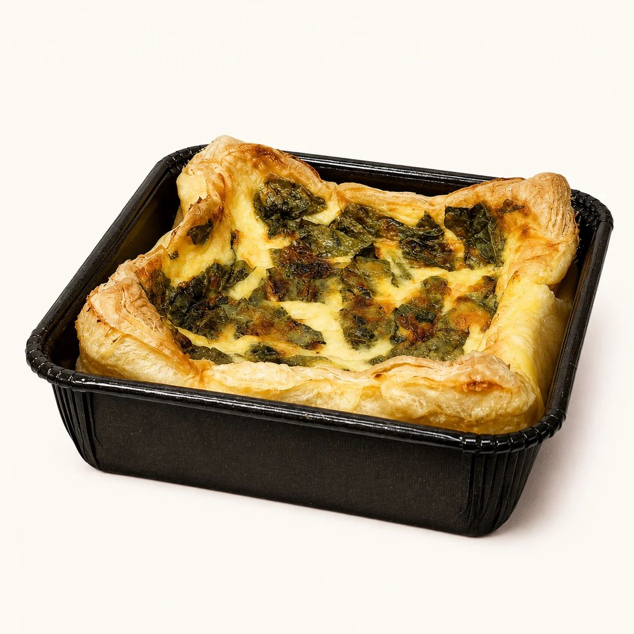 A square dish containing a savory spinach quiche with a golden flaky crust.