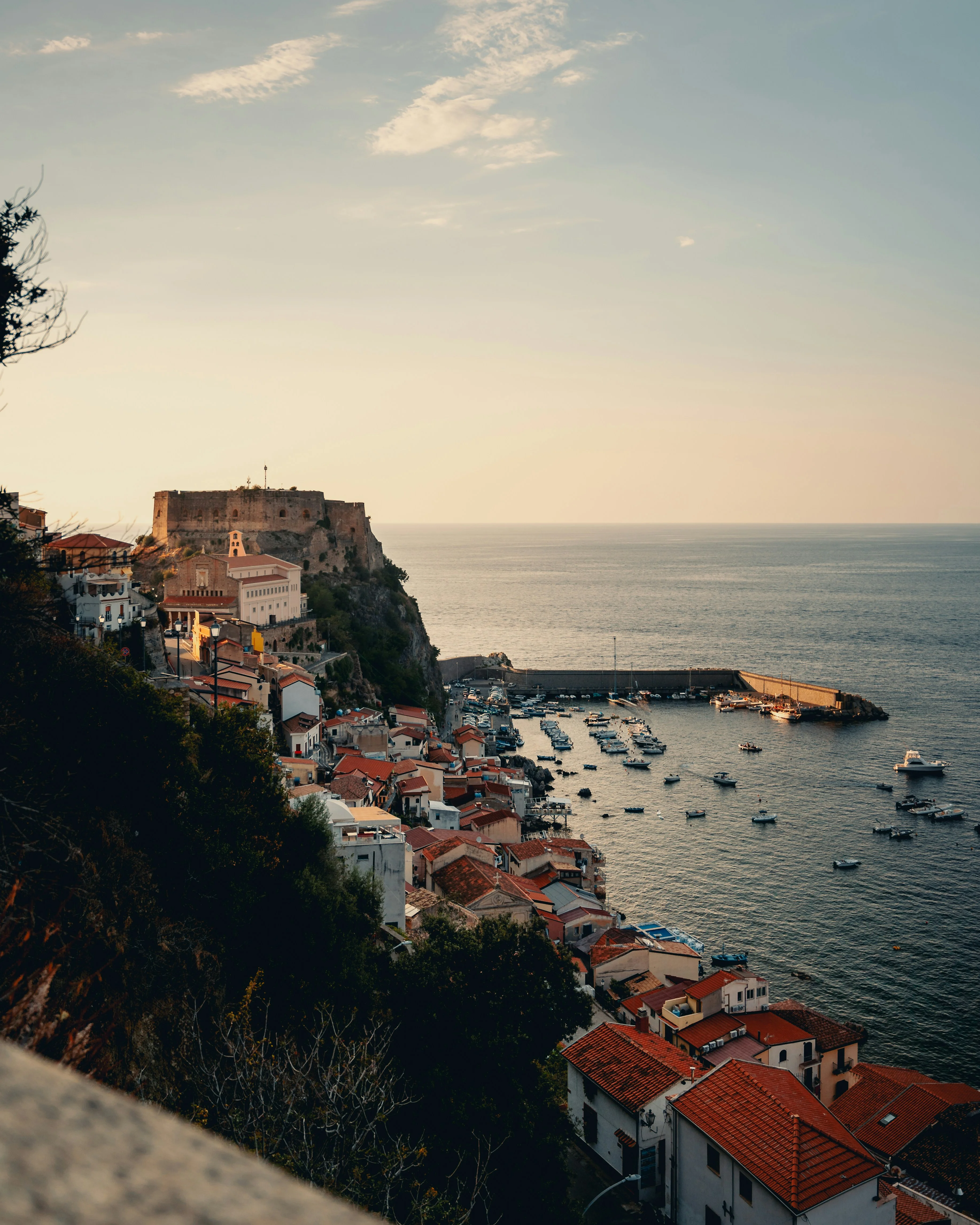 Scenic coastal view of a harbor with colorful houses and a castle