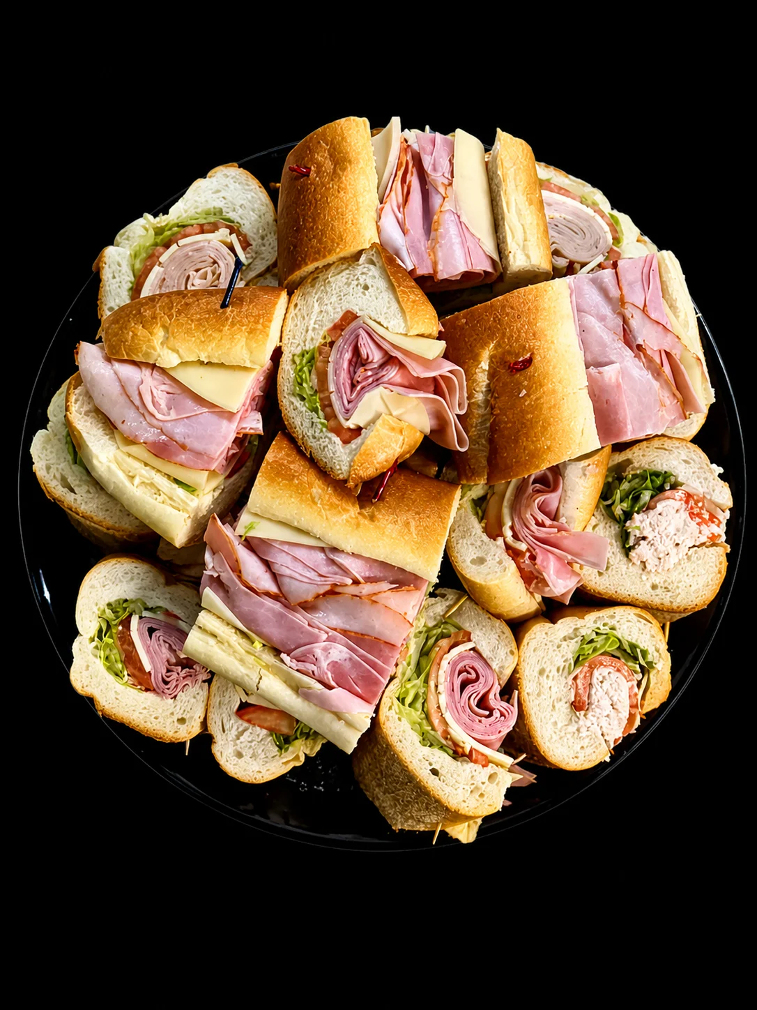 Assorted deli sandwiches on a black platter